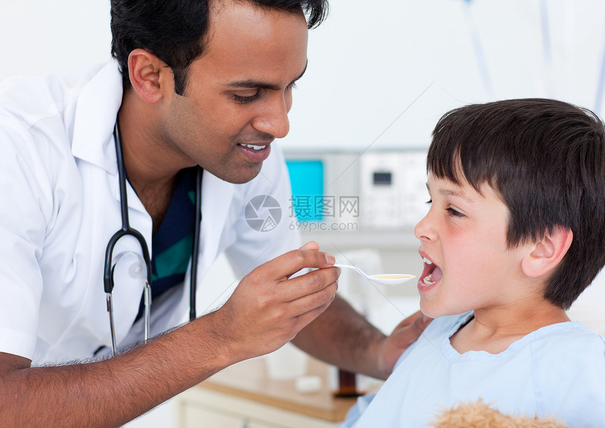 迷人的医生给一个小男孩送药图片