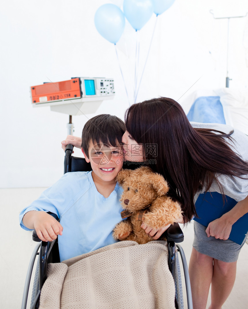 坐在轮椅上的快乐的小男孩和他的母亲图片