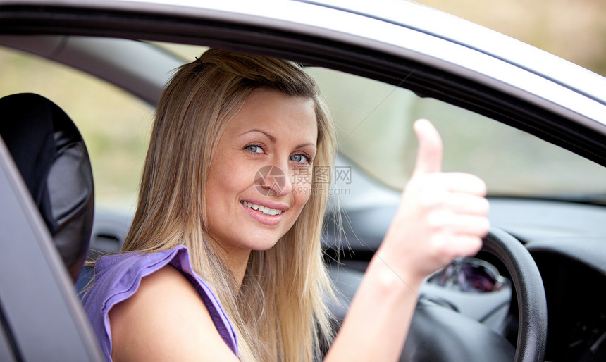 用拇指举起微笑的女驾驶员图片