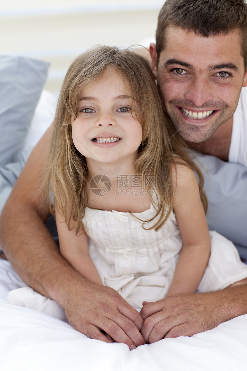 在床上微笑的父亲和女儿的肖像图片
