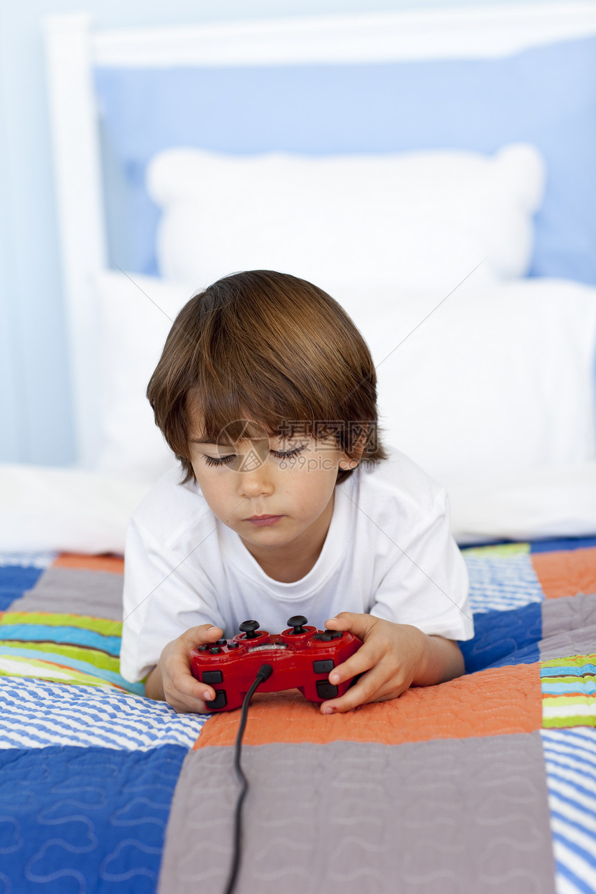 男孩在卧室里玩视频游戏图片