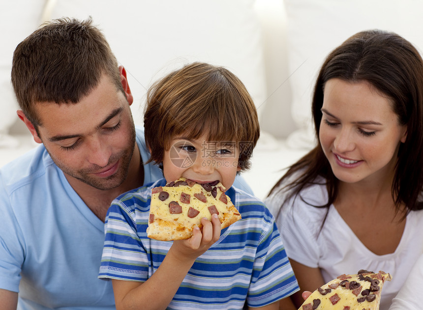 和父母一起吃比萨饼的快乐男孩图片