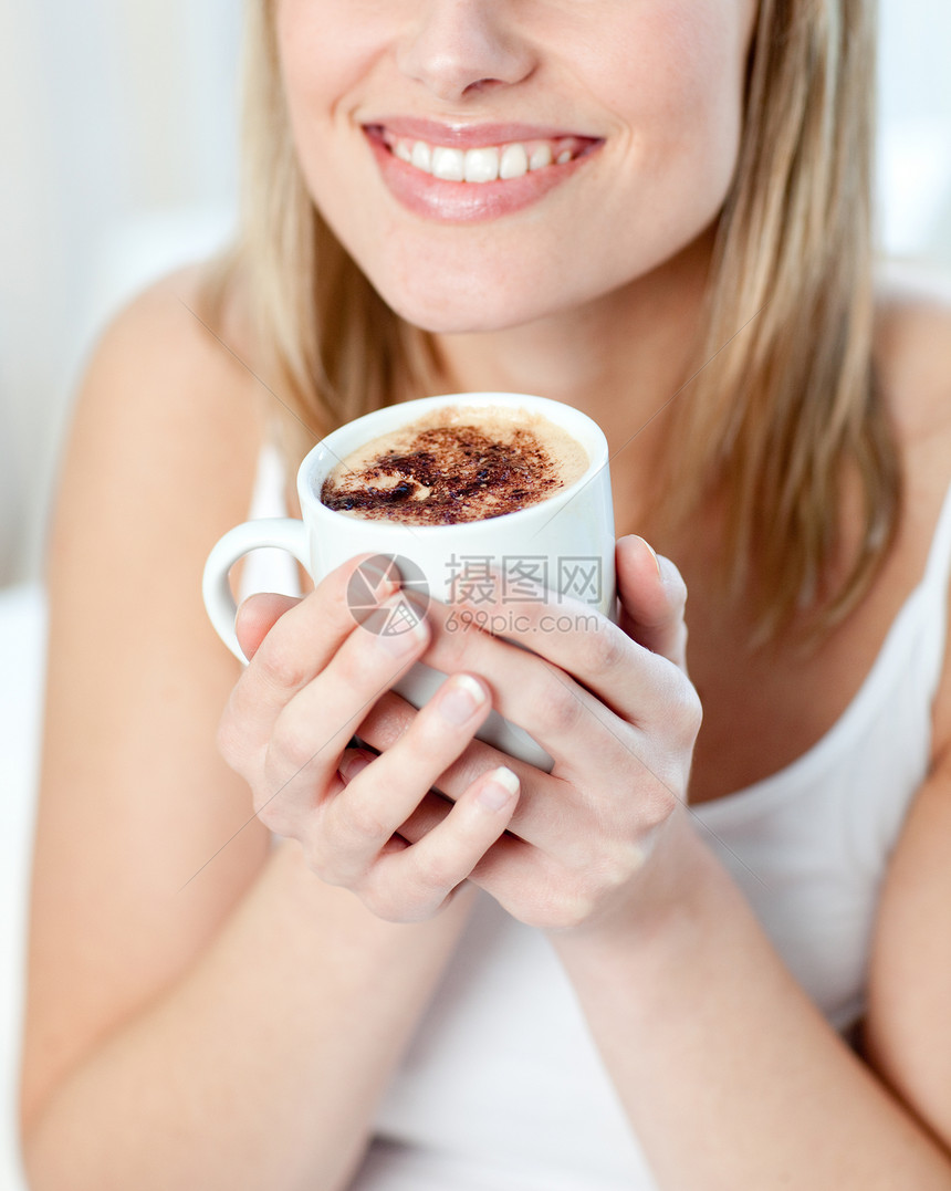 一个喝咖啡的笑着女人的肖像图片