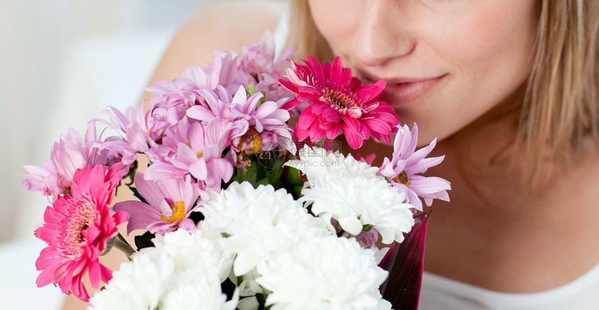 一个女人的近身 闻着一束鲜花的味道图片