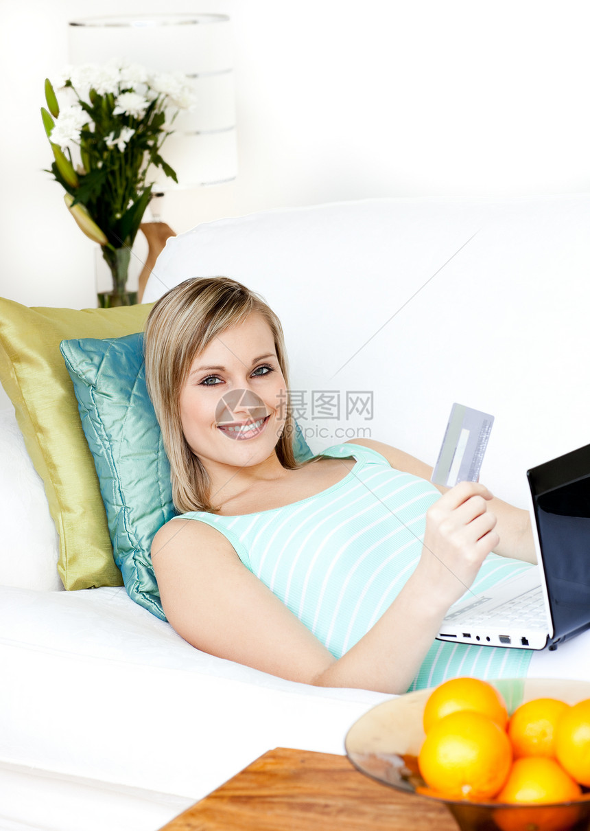 躺在沙发上的快乐妇女在线购物图片
