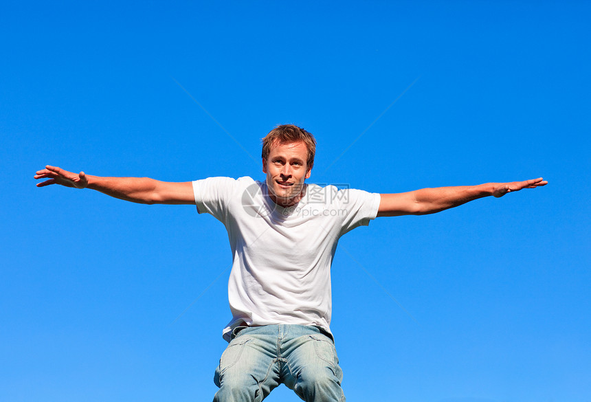 在蓝背景下跳跃的快乐男人图片