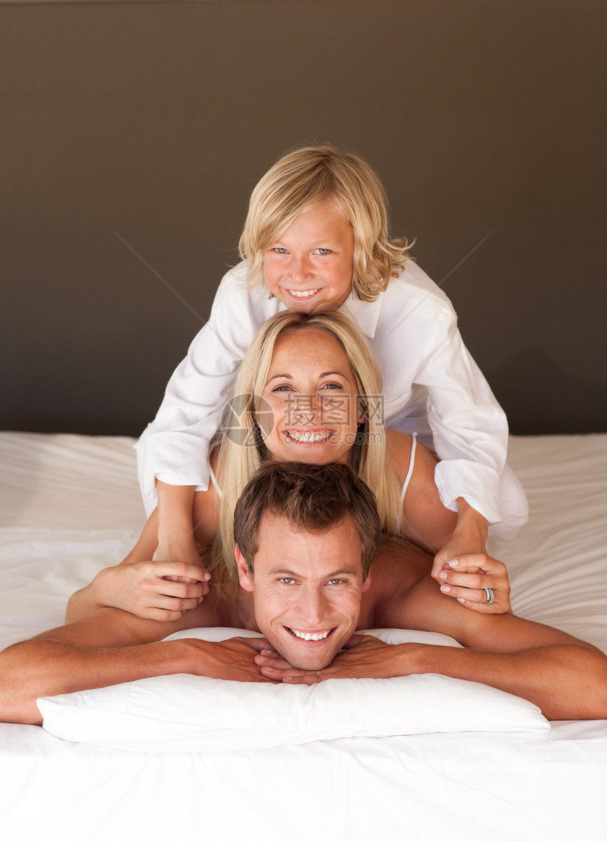 快乐的父母和孩子们在床上玩乐的肖像女性瑜伽男生男人夫妻孩子沉思冥想相机短裤图片