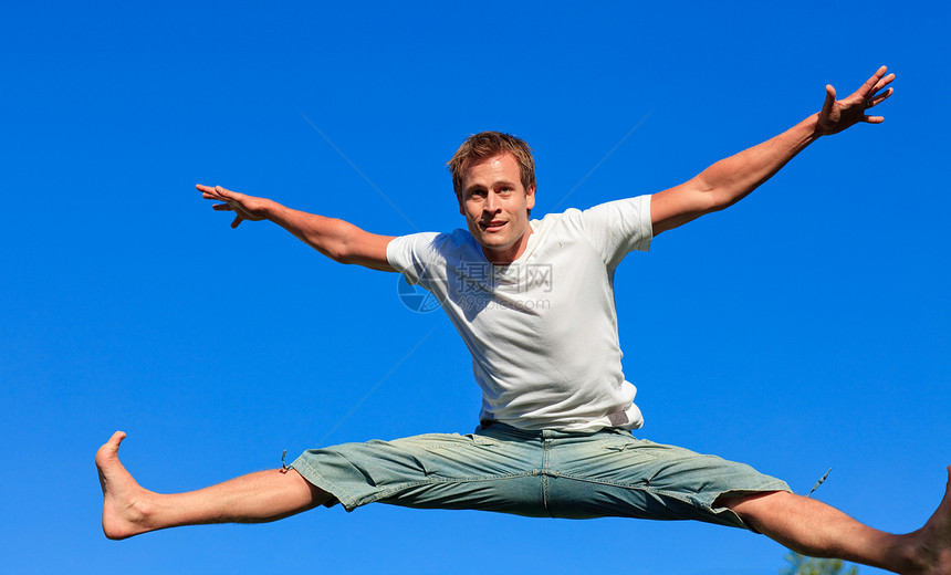 喜悦的男子在空中跳跃图片