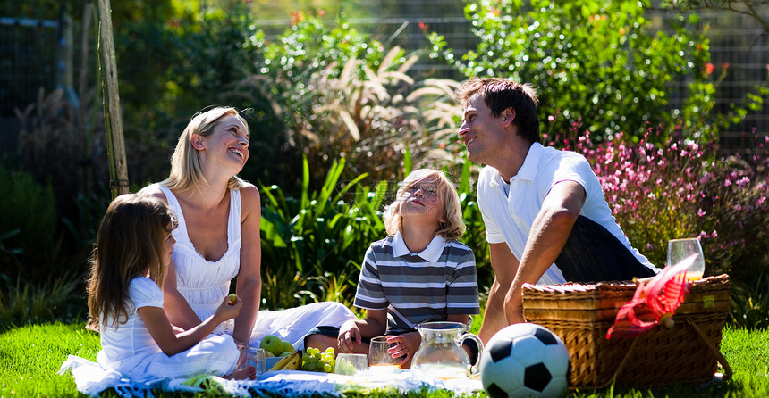 快乐的一家人享受日光在野餐中图片