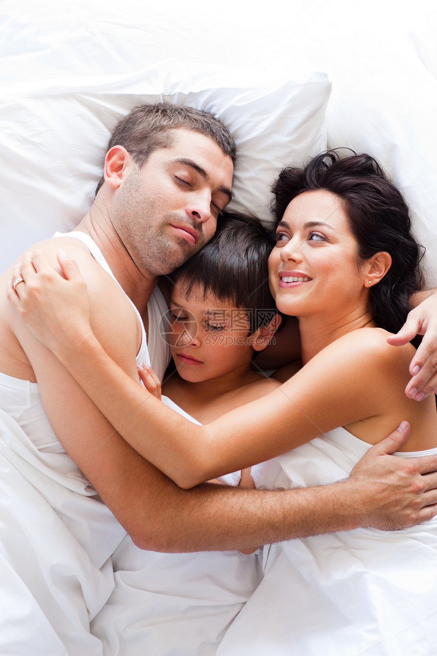 幸福的家庭在床上休息图片
