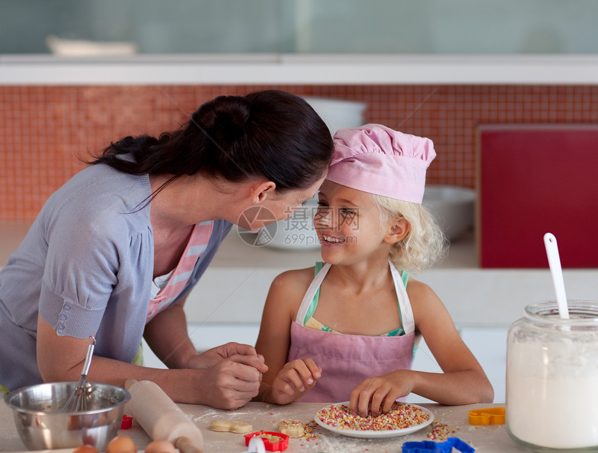 漂亮的母亲和女儿在厨房烘烤图片