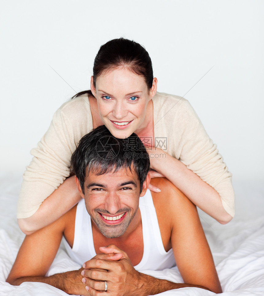 躺在白床上的一对幸福快乐的情侣图片