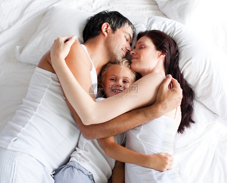 父母和女儿在床上放松图片