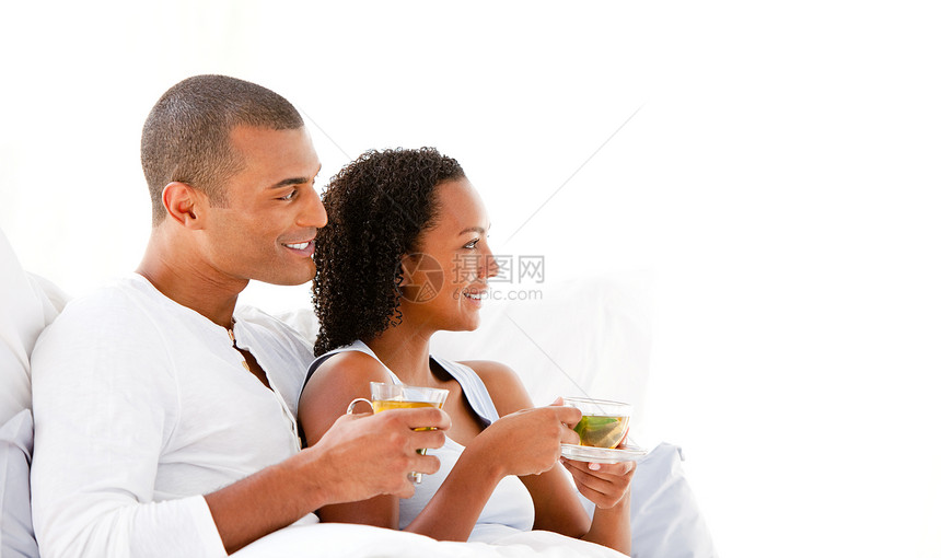 欢快的情侣在床上喝着一杯茶床单夫妇男性丈夫夫妻男朋友女性新婚唤醒拥抱图片