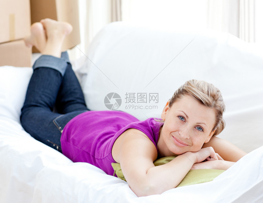 一个快乐的女人的肖像 在沙发上放轻松纸板包装长椅微笑地面房间开箱客厅幸福房地产图片