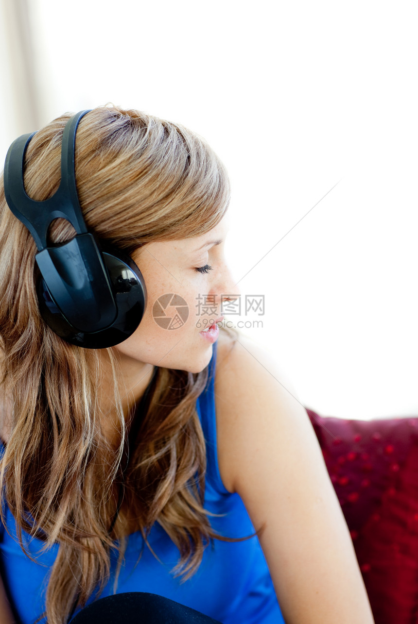 美丽的女人正在用耳机听音乐的音响图片