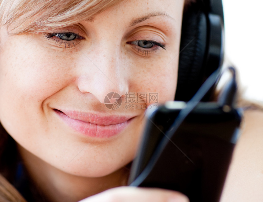 一位以耳机收听音乐的快乐女人的肖像图片