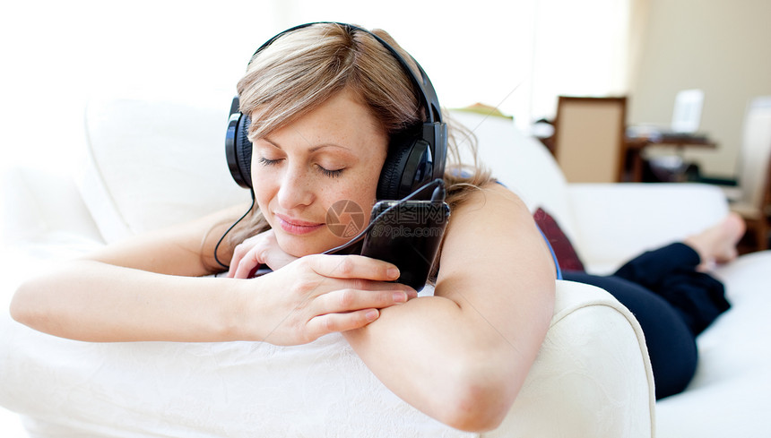 一位聪明女人的肖像 用耳机听音乐的图片