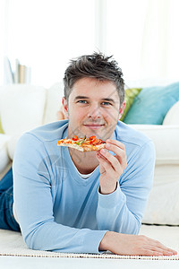 一个年轻人拿着比萨饼背景图片