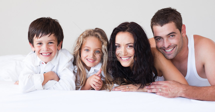 幸福的一家人一起躺在一起父母孩子母亲女性父亲家庭女儿孩子们女士卧室图片