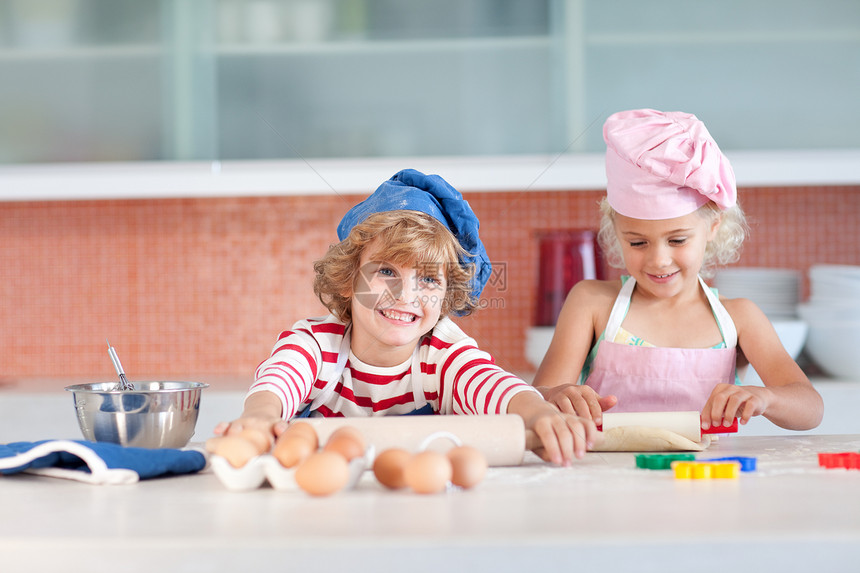 快乐的兄弟姐妹们做饼干乐趣孩子们女孩孩子烹饪童年食物厨房闲暇微笑图片