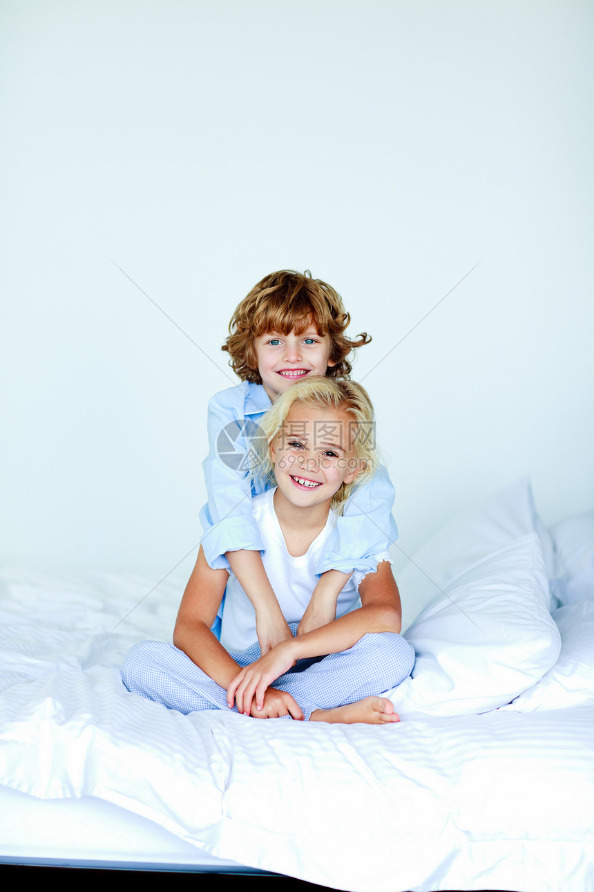 姐妹和兄弟在床上拥抱图片