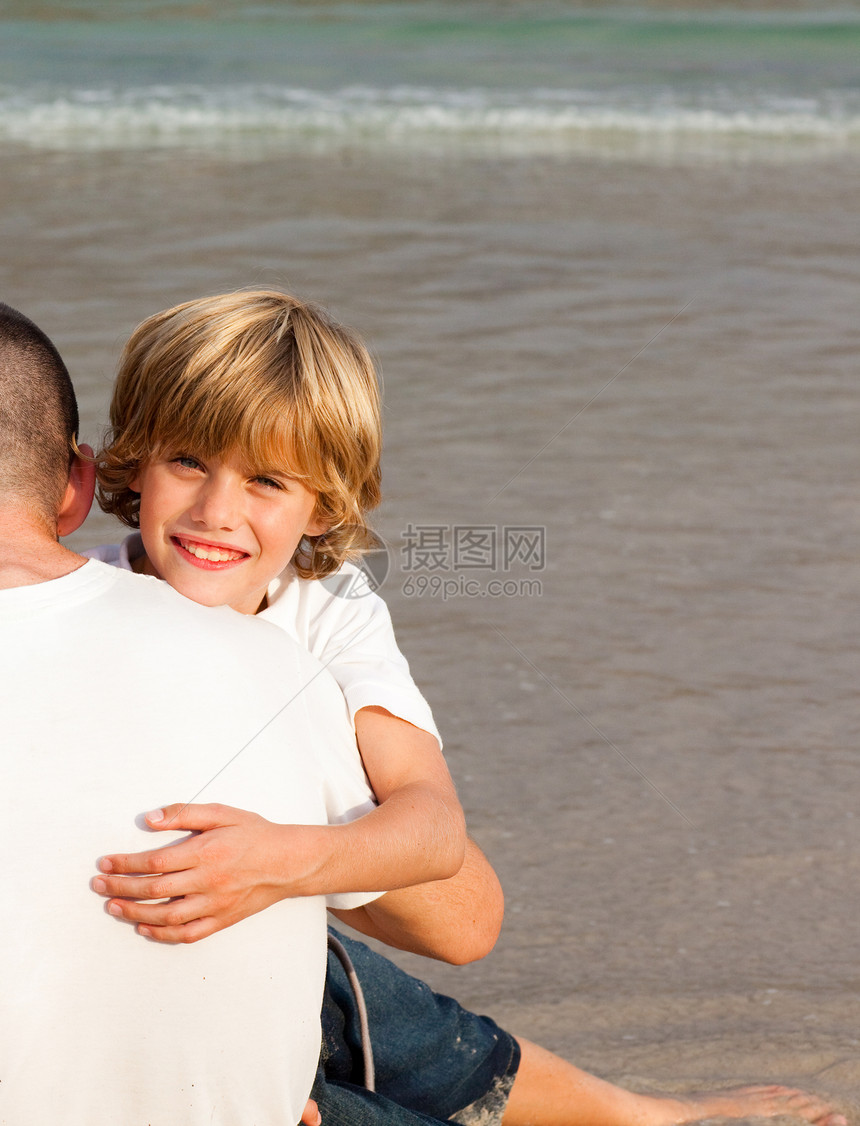 一个微笑的男孩拥抱他父亲的肖像图片