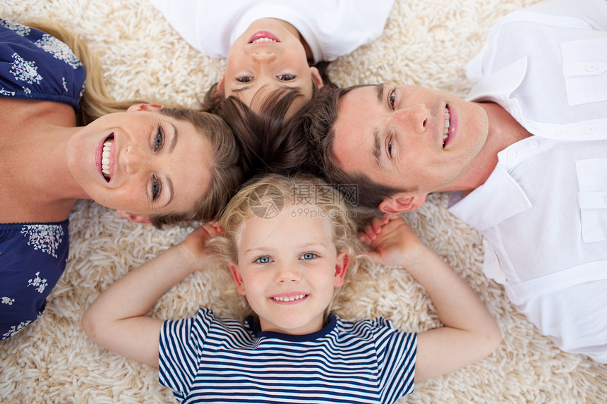 躺在地板上微笑的年轻家庭图片