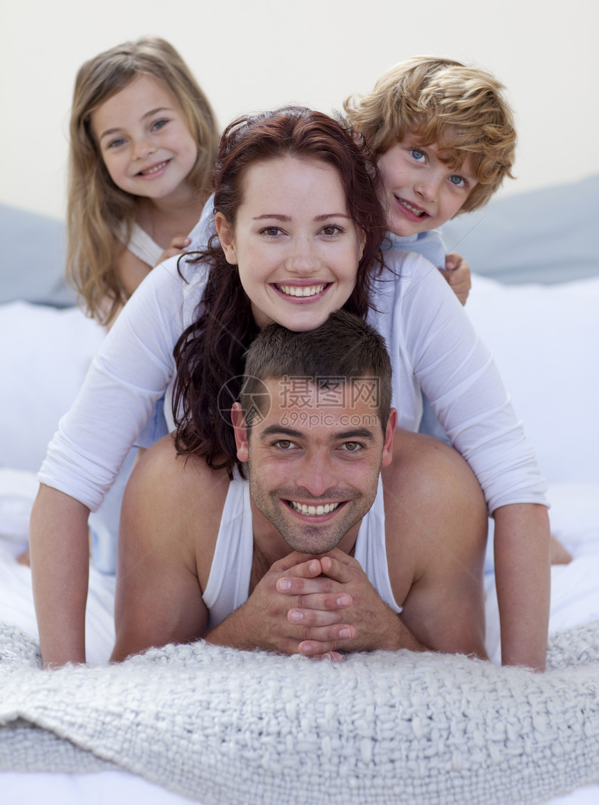 幸福家庭在床上玩乐的肖像图片