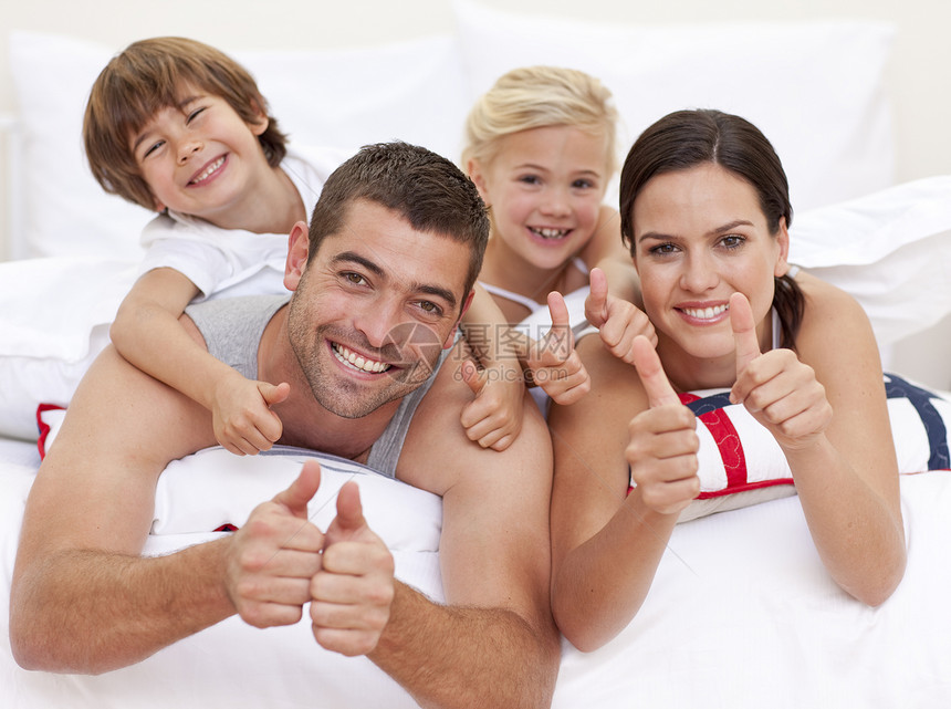 家人在床上玩 举起拇指父亲母亲孩子们卧室乐趣拥抱女性家庭女士儿子图片
