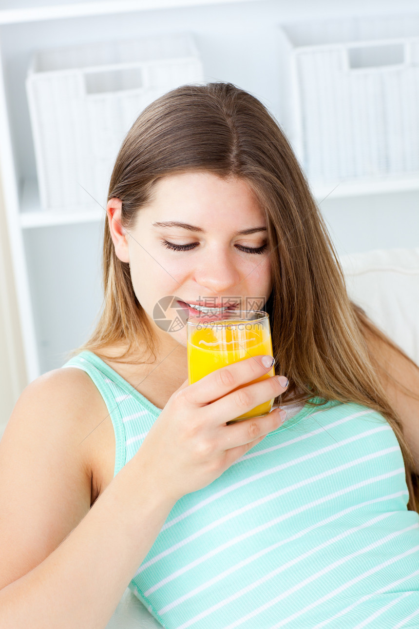 喝橙汁的白种年轻女子图片