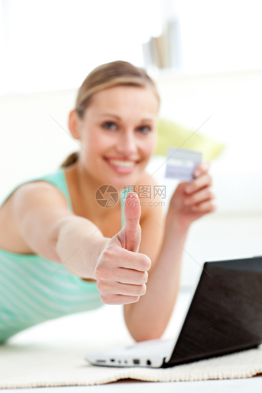 握着卡片的拇指举起大拇指 可爱的年轻女人图片