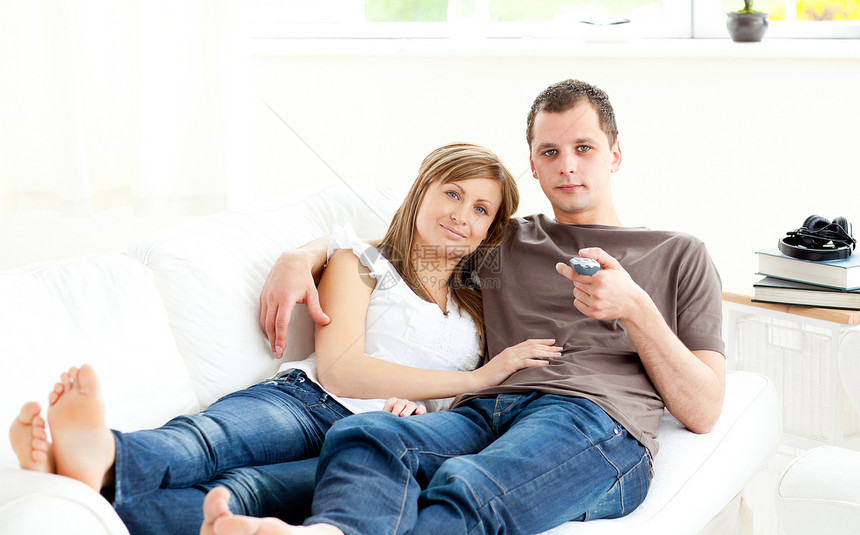 正面的caucasians夫妇在沙发上看电视图片