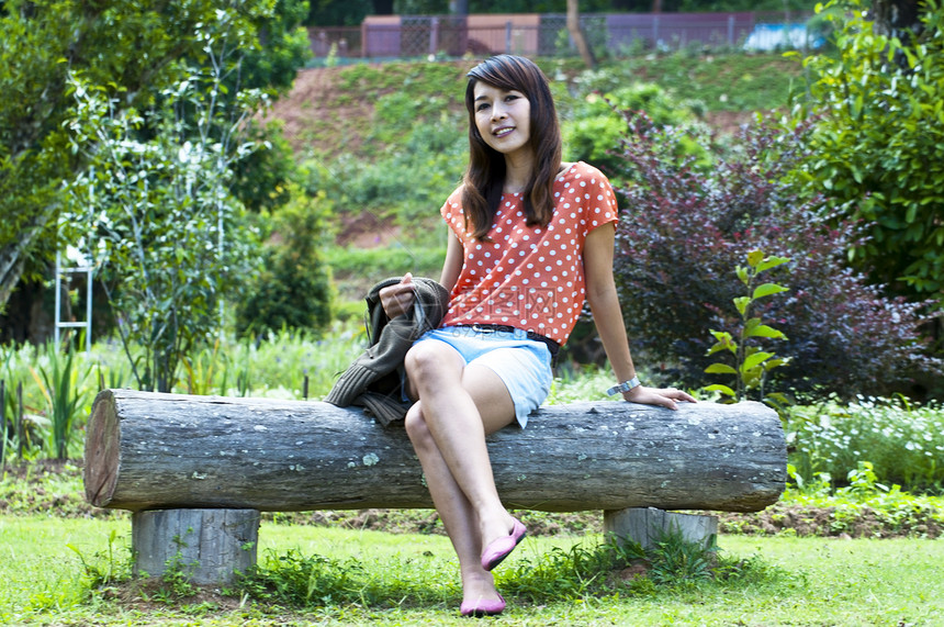 花园中亚洲年轻女性的肖像中年女士笑声微笑公园图片