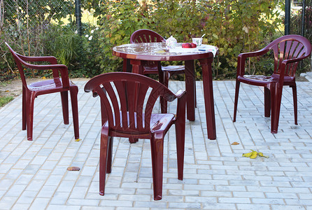 塑料家具鹅卵石商品露台红色椅子桌子多云村庄花园石头背景图片