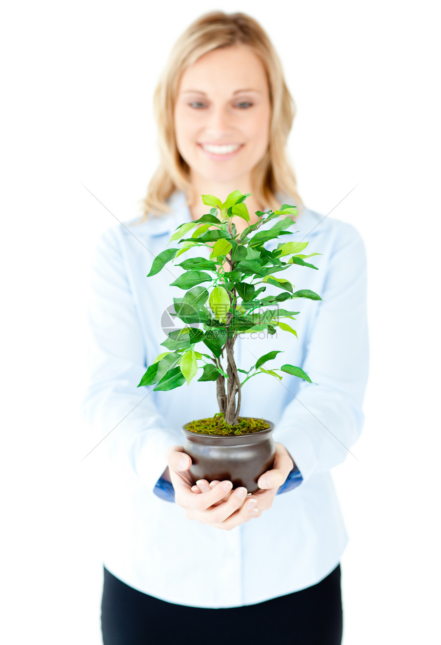 一位愉快的女商务人士向摄像头展示植物的肖像图片