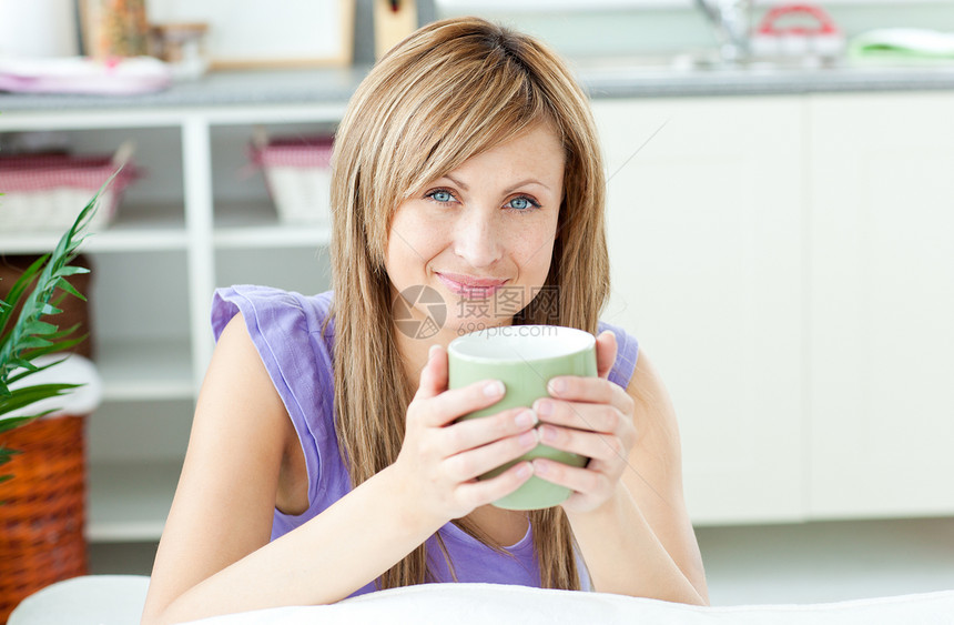 在厨房里喝咖啡的绿光女郎 拿着一杯咖啡图片