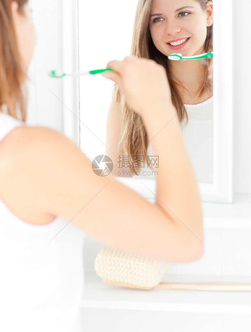 捕捉持牙刷的caucasian女人微笑洗涤白色女士卫生镜子刷子治疗牙科女性图片