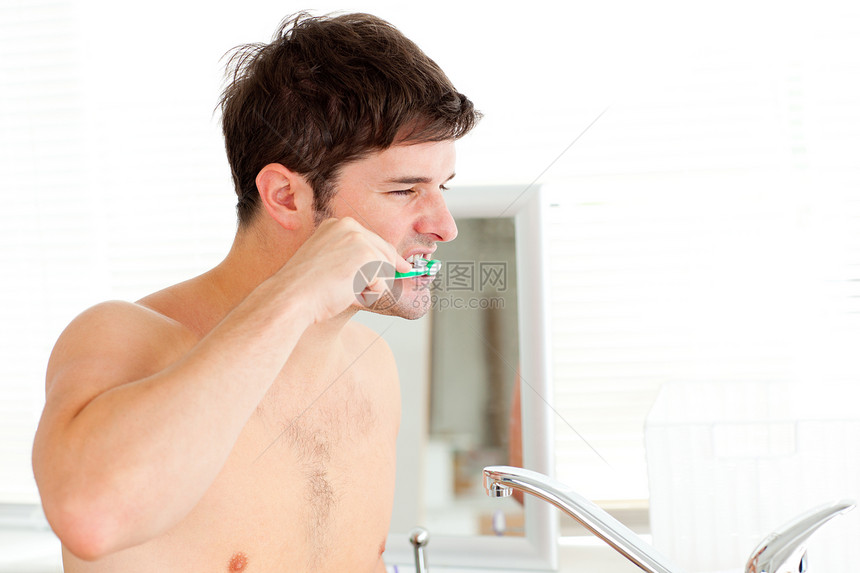 英俊的年轻人在洗手间刷牙图片