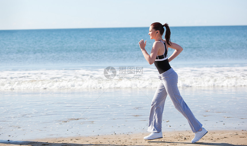 美丽的女人在海滩上奔跑行动火车日出竞技慢跑闲暇女士重量慢跑者跑步图片