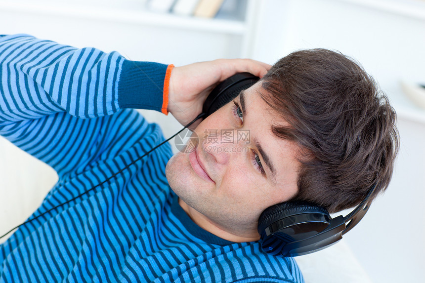 快乐的年轻人 带着耳机 在沙发上放松音乐图片