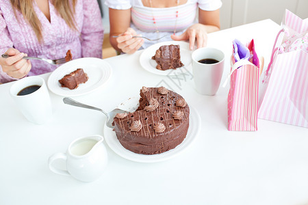 吃巧克力蛋糕的白人女性朋友的特写镜头背景图片
