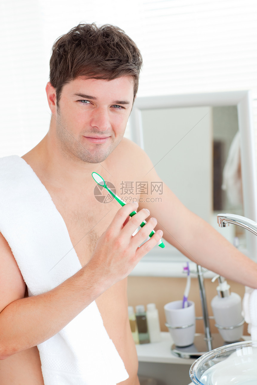 阳性青年男子 用毛巾在浴浴池刷牙图片