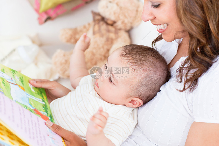 快乐的妈妈在一本书里给可爱的小儿子看图片