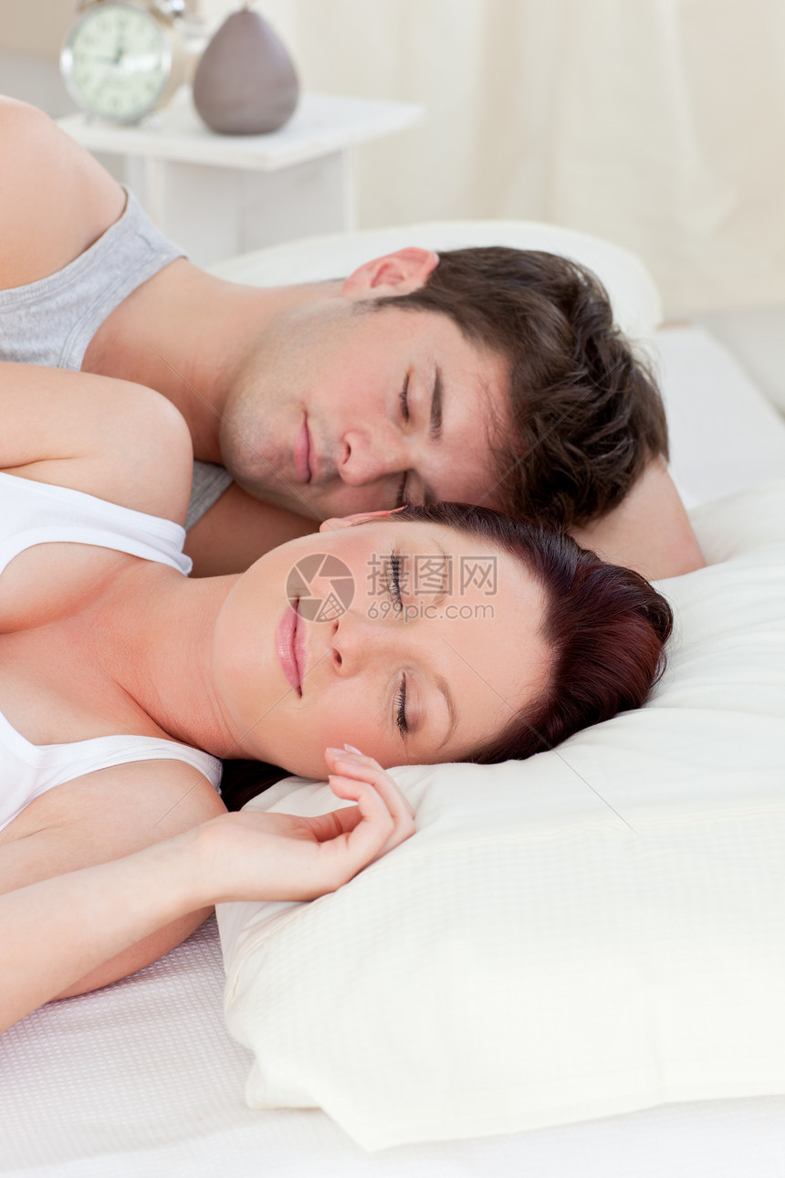 年轻的天主教夫妇睡在床上图片