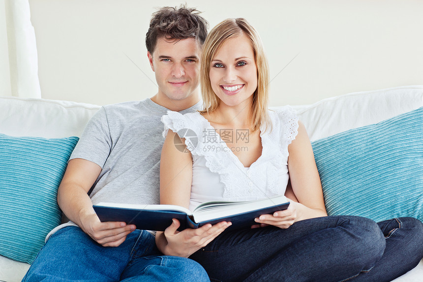 一对可爱的情侣一起看书 坐在家里沙发上图片