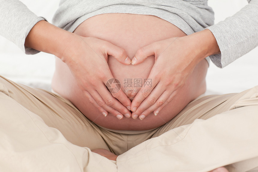 紧贴一个孕妇的近身 在她的肚子上做心脏标志几个月怀孕喜悦婴儿腹部女士妻子生活享受情感图片