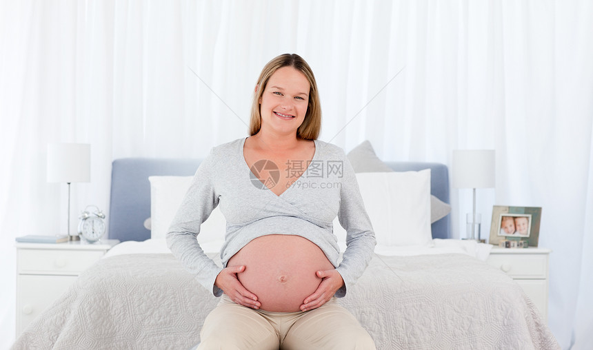 快乐的孕妇在她的卧室里图片