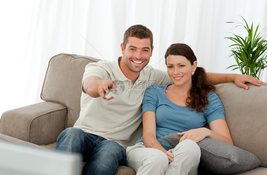 快乐的男人看电视 与他的女朋友坐在THY图片