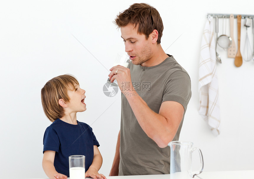 快乐的爸爸和儿子一起喝牛奶图片